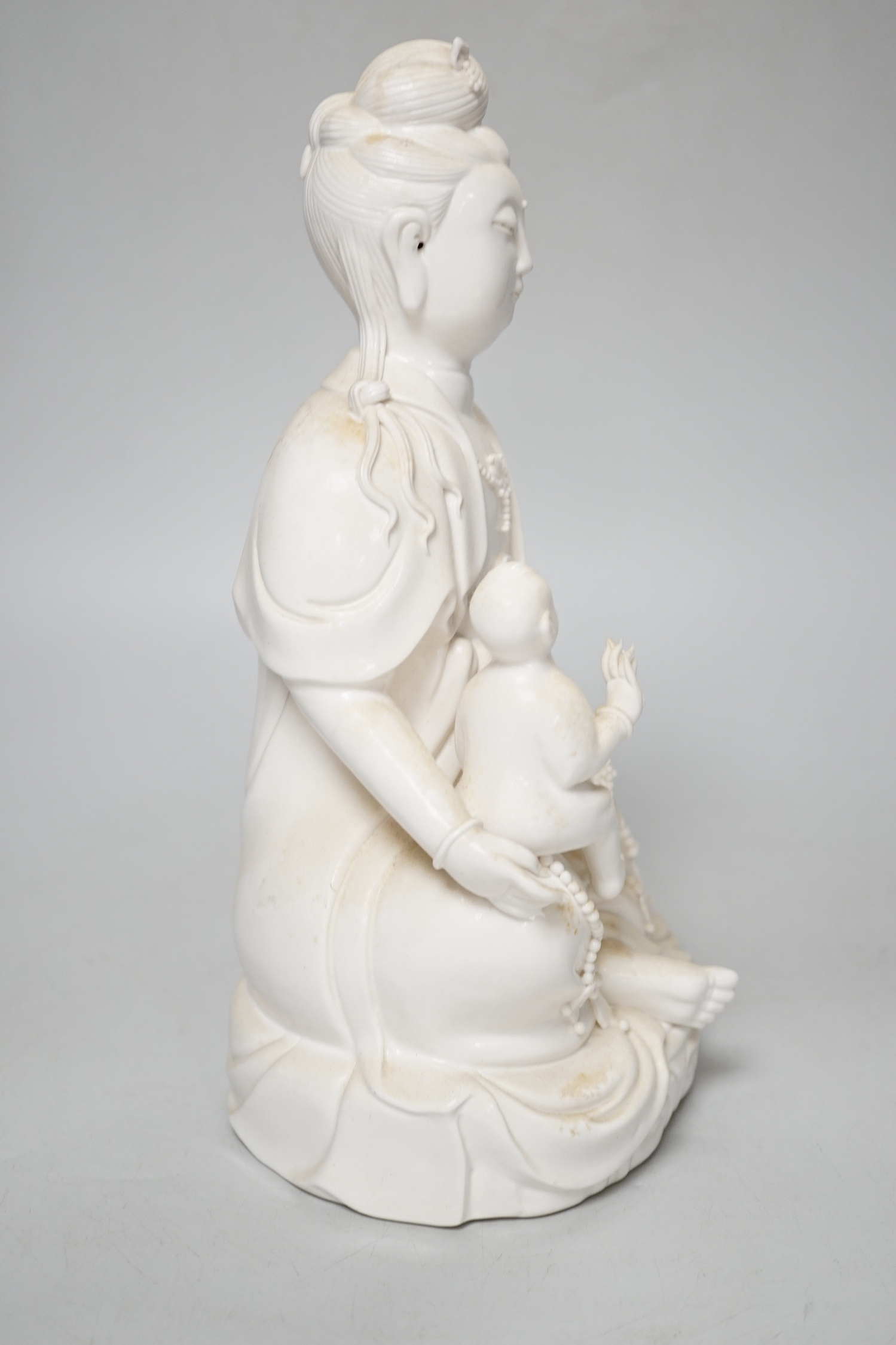 A blanc de chine figure of Guanyin and a child, 27cm